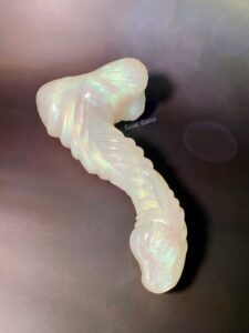 Mothman dildo laying down on the same black bokeh light background.