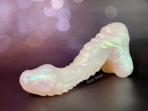 Mothman dildo posed laying forward, propped on the ball base. The curves are accentuated in this pose.