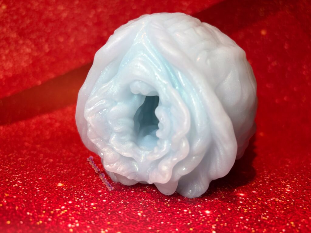 Hawthorn stroker from Hodge Podge Entourage. The front entrance is shown, displaying the petals and folds. It's sky blue in color, with mother-of-pearl shimmer
