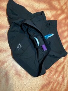 Black SnugHer boxer harness from Crassie with a tentacle dildo in the o ring and a purple bullet vibrator in he top pocket. 