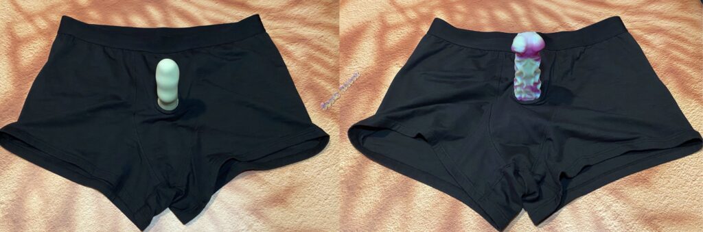 Two side by side picture of the black SnugHer harness from Crassie. There is a green dildo in the harness on one photo and a green and purple, textured dildo in the harness on the other photo. 