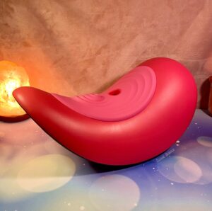 The Rider Desire Saddle sitting on a flat surface, a salt lamp can be seen behind it.