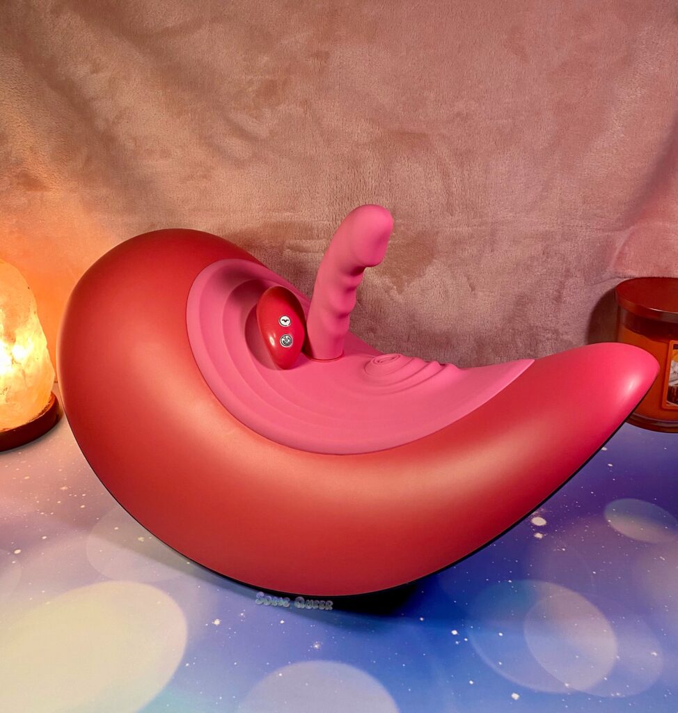 The Rider Desire with the vibrating attachment docked and the remote control propped on it.