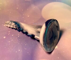 Thalia tentacle laying down where you can see the suction cup bottom. Squidly CO's logo can be faintly seen on the bottom. 