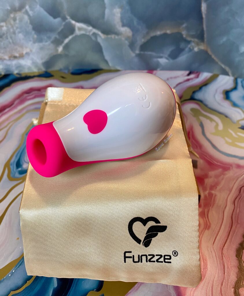 Pink O Sucker from Funzze, sitting on top of the gold storage bag.